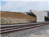 Completed bridge pier stands in front of new soil embankment