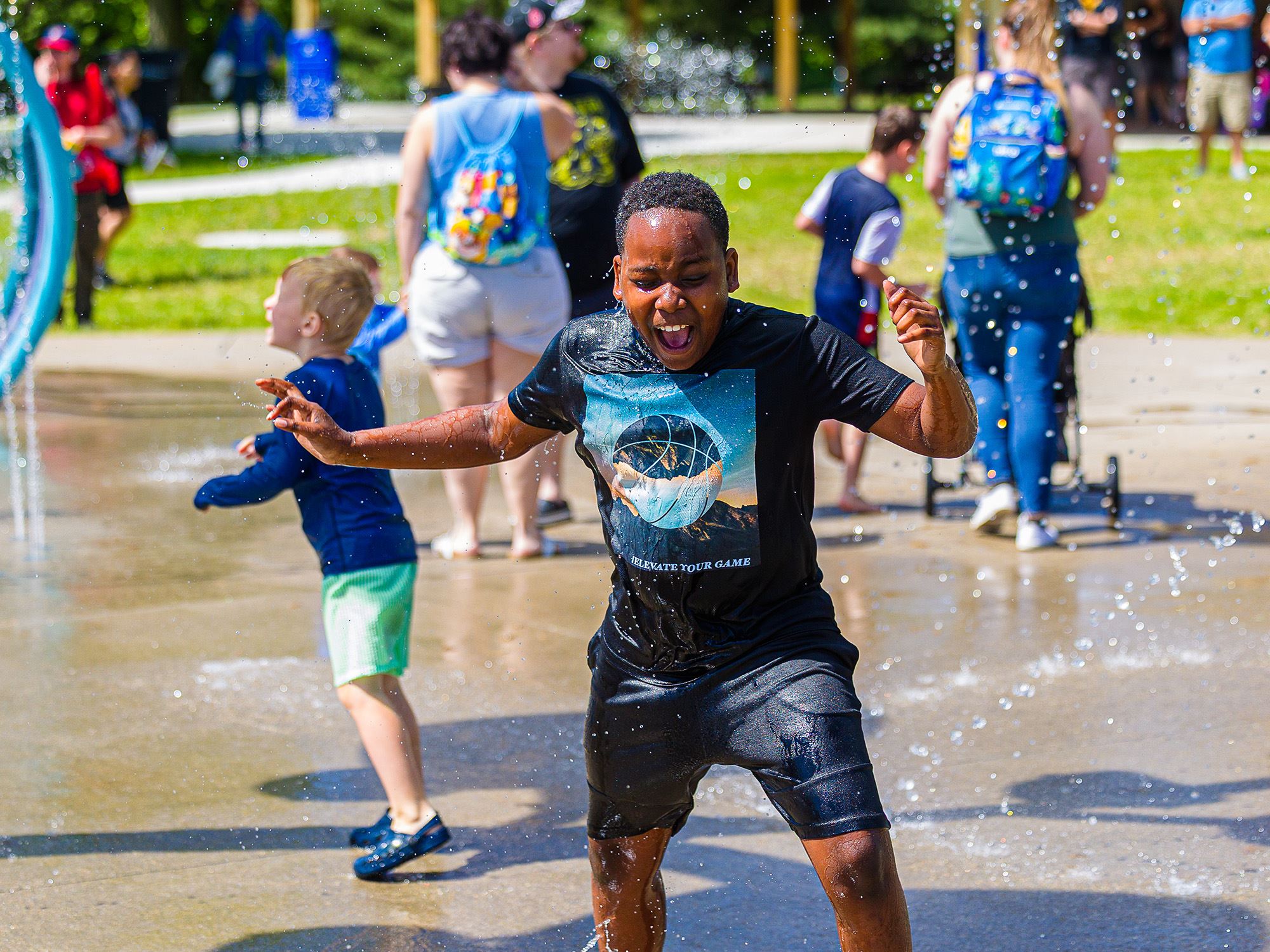 Boy playing in water spray at splash pad