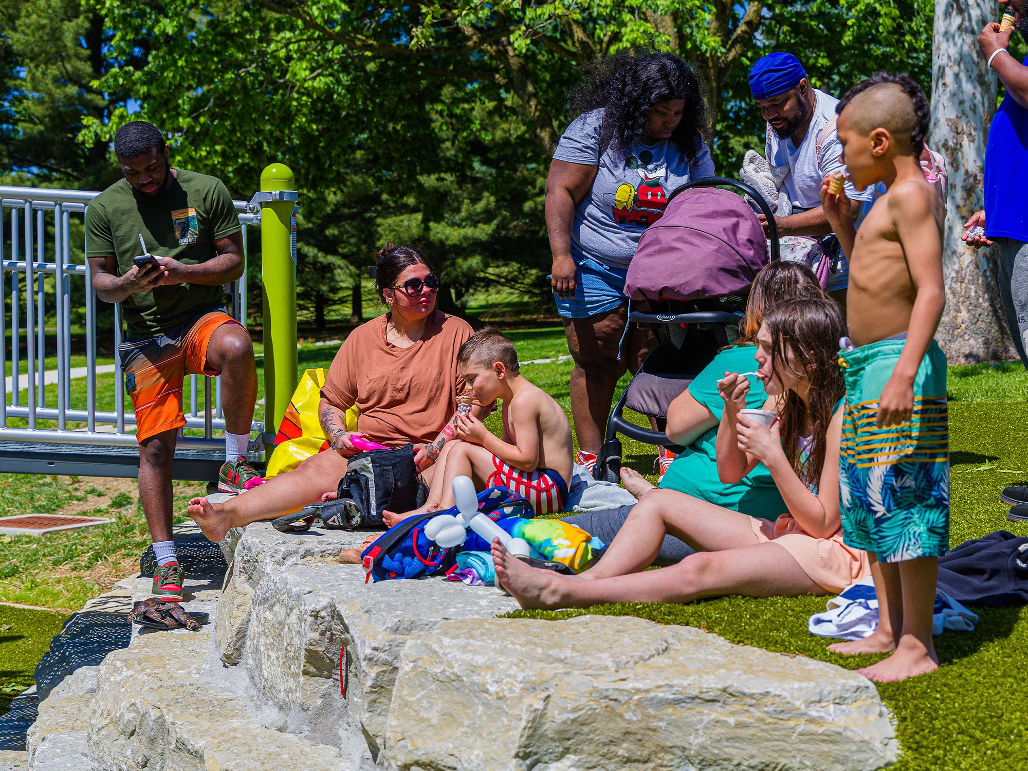 Families sitting on rocks eating snacks at the playground