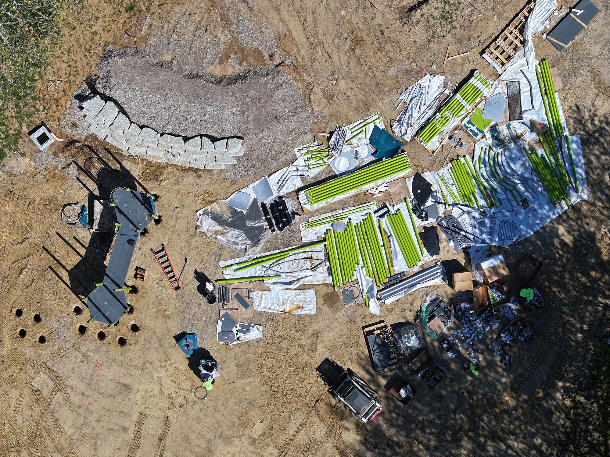 Playground parts and materials laid out at site